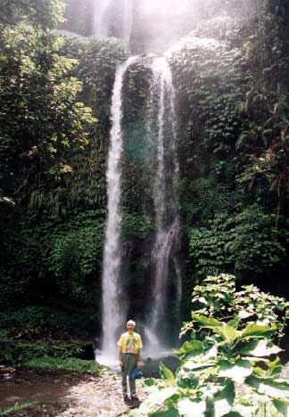 Air Terjun (waterfall) Singang Gila on the north side of Mt. Rinjani. The top part of the falls is taller. It is set in a forest surrounded by upland rice fields. Most of the path is steps and it is a steep climb down, then back up. The guides are boys who live nearby and have a little English. Our young guide lives there and has a dream of building his own losmen, a cheap tourist hotel. Clare Ann slipped on the stone steps as we began to climb back up, and the guide insisted on holding her arm for the whole climb. - jpg - 33030 Bytes